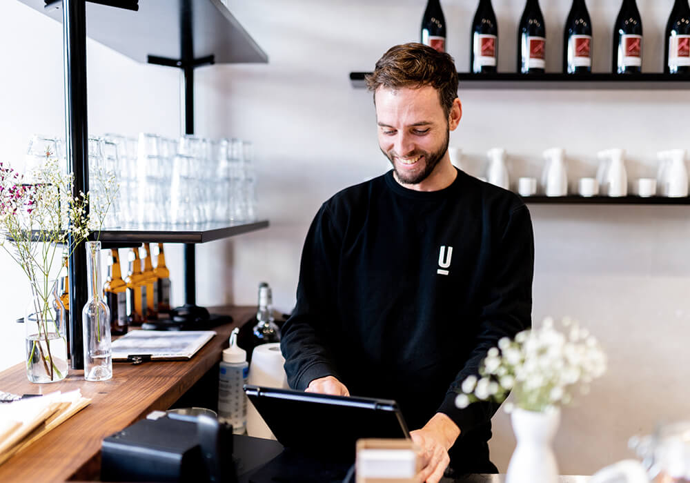Mitarbeiter arbeitet hinter der Theke am Lightspeed Kassensystem